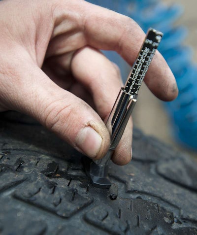 Measuring tire tread depth on light truck tire.