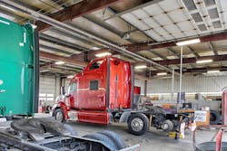 Semi-trucks receiving maintenance work in a garage