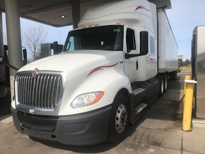 white semi truck parked getting fuel
