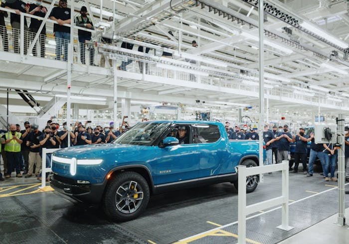 Rivian CEO RJ Scaringe is shown behind the wheel of the nation's first mass-produced electric pickup, the R1T.