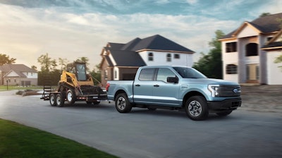 A photo released by Ford shows the 2022 F-150 Lightning towing a track loader.