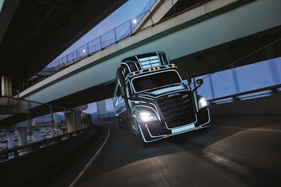 A Freightliner electric Class 8 truck under an overpass.