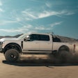Shelby 2023 F-250 Super Baja side view driving in desert