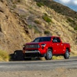 red 2024 Toyota Tacoma Limited driving on mountain road